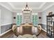 Bright dining room with hardwood floors, a modern chandelier, and sophisticated furnishings at 704 Branchview Ct, Mcdonough, GA 30252