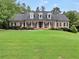 Inviting brick home with a lush green lawn, dormer windows, and rocking chairs on the front porch at 704 Branchview Ct, Mcdonough, GA 30252