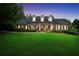 Charming brick home featuring a well-manicured lawn and classic colonial-style architecture at dusk at 704 Branchview Ct, Mcdonough, GA 30252