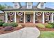 Inviting front porch with classic columns, patriotic bunting, and comfortable rocking chairs at 704 Branchview Ct, Mcdonough, GA 30252