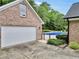 A brick house with a white garage door near a beautiful fenced in pool at 704 Branchview Ct, Mcdonough, GA 30252