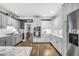Bright kitchen features white cabinets, stainless steel appliances, and dark hardwood floors at 704 Branchview Ct, Mcdonough, GA 30252