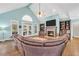 Open-concept living room with hardwood floors, vaulted ceiling, fireplace, and backyard views at 704 Branchview Ct, Mcdonough, GA 30252