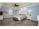 Large primary bedroom with a tray ceiling, carpet floors, and neutral decor at 704 Branchview Ct, Mcdonough, GA 30252