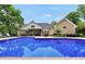 Back exterior view of the home highlighting the pristine blue pool and patio area at 704 Branchview Ct, Mcdonough, GA 30252
