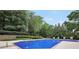 A clean swimming pool surrounded by trees and lawn furniture at 704 Branchview Ct, Mcdonough, GA 30252