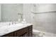 Bathroom featuring white marble tiling, glass shower, and dark wood vanity with a marble countertop at 1822 Chartwell Trce, Stone Mountain, GA 30087