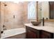 Bathroom featuring a decorative sink, dark wood vanity, and tiled shower/tub with glass enclosure at 1822 Chartwell Trce, Stone Mountain, GA 30087
