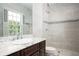 Bathroom featuring marble countertop, dark wood cabinets, a walk-in shower and sleek fixtures at 1822 Chartwell Trce, Stone Mountain, GA 30087