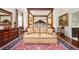 Bedroom featuring a four-poster bed, sitting area, decorative rug, and classic wood furnishings at 1822 Chartwell Trce, Stone Mountain, GA 30087
