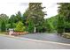 A long driveway leads to an estate gate with colorful landscaping and mature trees at 1822 Chartwell Trce, Stone Mountain, GA 30087