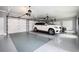 Spacious three-car garage with epoxy floor, ample lighting, and room for storage, showcasing two luxury cars at 1822 Chartwell Trce, Stone Mountain, GA 30087