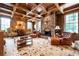 Elegant living room featuring a stone fireplace, coffered ceiling, and large windows at 1822 Chartwell Trce, Stone Mountain, GA 30087