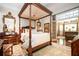 Luxurious primary bedroom with a canopy bed, ornate mirror, and hardwood floors at 1822 Chartwell Trce, Stone Mountain, GA 30087