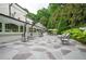 Expansive outdoor patio with stone flooring, comfortable seating arrangements, and a picturesque backyard view with mature trees at 1822 Chartwell Trce, Stone Mountain, GA 30087
