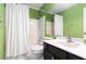 Bathroom with green walls, shower, vanity, and bright lighting at 1908 Brittania Cir, Woodstock, GA 30188