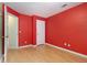 Empty red bedroom features hardwood floors and a doorway at 1908 Brittania Cir, Woodstock, GA 30188