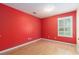 Empty red bedroom features hardwood floors and a window with bright, natural light at 1908 Brittania Cir, Woodstock, GA 30188