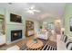 Bright living room featuring a fireplace, ceiling fan, and open access to the dining area and the rest of the house at 1908 Brittania Cir, Woodstock, GA 30188