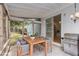 This screened porch features a wood dining table with grey wicker chairs and stainless steel grill at 1908 Brittania Cir, Woodstock, GA 30188