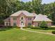 Brick home with manicured lawn and mature landscaping with a pathway to the front door at 320 Yellowroot Ln, Sandy Springs, GA 30350