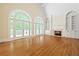 Bright living room with hardwood floors, tall windows, a fireplace, and custom built-in shelving at 320 Yellowroot Ln, Sandy Springs, GA 30350