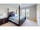 This bedroom features a large bed with a blue plaid cover, dark furniture, and a sunny window at 4535 Sunflower Cir, Cumming, GA 30040