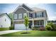 Inviting two-story home with stone accents, covered front porch, and a well-kept lawn with mature tree at 4535 Sunflower Cir, Cumming, GA 30040