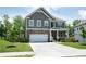 Two-story home with gray siding, stone accents, a two-car garage, driveway, and manicured front lawn at 4535 Sunflower Cir, Cumming, GA 30040