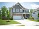 Charming two-story home featuring a stone facade, gray siding, and a two-car garage on a well-manicured lawn at 4535 Sunflower Cir, Cumming, GA 30040