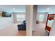 Open living room featuring a blue sofa, wall-mounted TV, and view into the adjacent bedroom at 4535 Sunflower Cir, Cumming, GA 30040