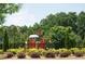 A colorful community playground surrounded by trees, shrubs, and a fence creating a secure play environment at 4535 Sunflower Cir, Cumming, GA 30040
