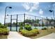 Exterior view of a community tennis court with lighting, fencing, landscaping, and community homes at 4535 Sunflower Cir, Cumming, GA 30040