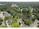 Aerial view of a neighborhood showcasing homes, a tranquil lake, mature trees, and winding streets at 3260 Kingshouse Commons, Johns Creek, GA 30022