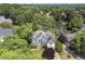 Stunning aerial view of a home nestled among trees with lake access, showcasing its private setting at 3260 Kingshouse Commons, Johns Creek, GA 30022