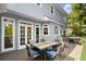 Back deck with table and grill; backyard view of home with white trim and blue siding at 3260 Kingshouse Commons, Johns Creek, GA 30022
