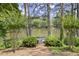 Lush backyard with a wooden deck, lake view and mature trees offer serene relaxation at 3260 Kingshouse Commons, Johns Creek, GA 30022