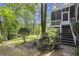 Exterior of a home featuring a porch and a lush backyard with mature trees and landscaping at 3260 Kingshouse Commons, Johns Creek, GA 30022