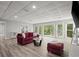 Open basement layout featuring a red sofa, a glass coffee table, and plenty of natural light at 3260 Kingshouse Commons, Johns Creek, GA 30022