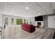 Finished basement with a red sofa, fireplace, and large windows with backyard views at 3260 Kingshouse Commons, Johns Creek, GA 30022