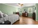 Bedroom with mint-green walls, a bed, two windows, and hardwood floors at 3260 Kingshouse Commons, Johns Creek, GA 30022