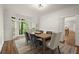 Dining room featuring a wooden table, velvet chairs, and natural light from a bay window at 3260 Kingshouse Commons, Johns Creek, GA 30022