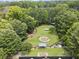 Aerial view of a dog park showing agility equipment, green space, and shaded seating areas at 3260 Kingshouse Commons, Johns Creek, GA 30022