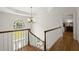 Hallway with hardwood floors, chandelier, and natural light from a half-round window at 3260 Kingshouse Commons, Johns Creek, GA 30022