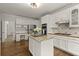 Bright kitchen with stainless appliances, center island with granite countertops and white cabinets at 3260 Kingshouse Commons, Johns Creek, GA 30022