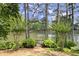 Picturesque view of the lake from a private dock, surrounded by mature trees and landscaping at 3260 Kingshouse Commons, Johns Creek, GA 30022