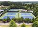 Overhead view of tennis courts showing well-maintained blue courts surrounded by green trees at 3260 Kingshouse Commons, Johns Creek, GA 30022