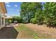 A private backyard features mature trees and a stone patio with grill at 4535 Vanadium Bnd, Cumming, GA 30040