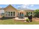 A cozy backyard features a stone patio, grill, lush lawn, and privacy hedges at 4535 Vanadium Bnd, Cumming, GA 30040