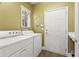 Bright laundry room with white washer, dryer, and access door at 4535 Vanadium Bnd, Cumming, GA 30040
